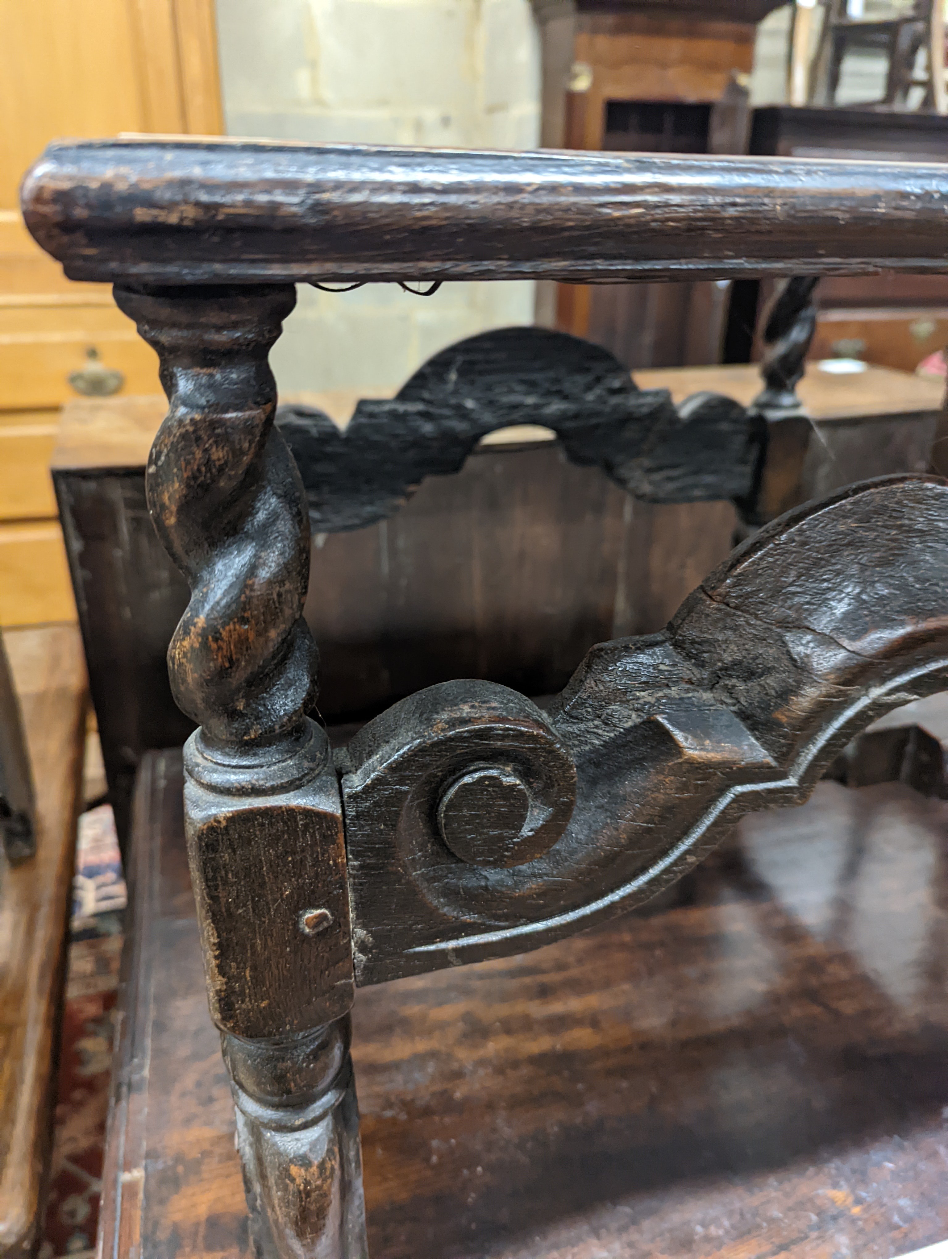 A 17th century style carved oak stool, with caned seat and H stretcher, width 47cm, depth 46cm, height 42cm